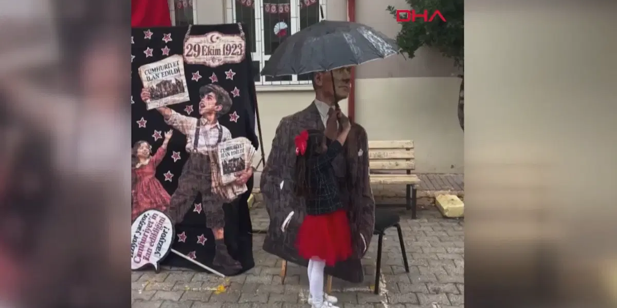 Atatürk maketini yağmurdan şemsiyeyle korudu